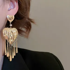 Chic gold heart fringe earrings featuring hammered metal texture and sparkling rhinestone