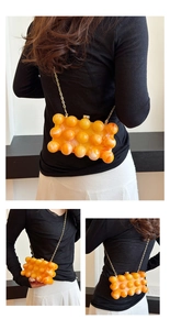 Détails du sac boîte en acrylique orange avec anse à perles et chaîne dorée