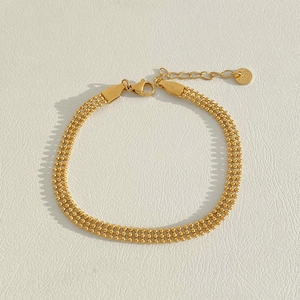 Détail du bracelet à triple rangée de perles dorées avec étiquette S925 et fermoir réglable
