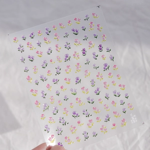 Detailed view of 3D embossed tulip nail stickers in pink, purple and yellow shades