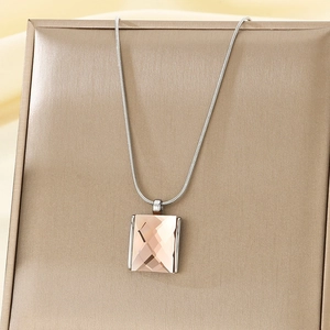 Detailed view of champagne rectangle crystal pendant with silver snake chain on gift box