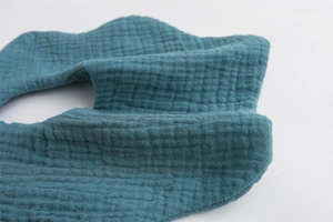 Macro detail of the soft 6-layer muslin cotton fabric on a teal baby bib