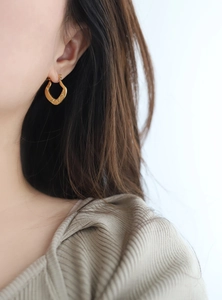 Detailed view of vintage gold horseshoe chain hoop earrings with hammered texture