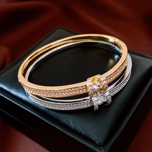 Detail of 18K gold-plated oval bangle featuring pavé-set stones and buckle clasp