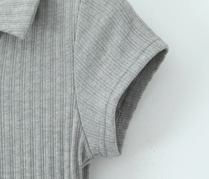 Gros plan détaillé du col polo en maille côtelée grise et de la texture du tissu