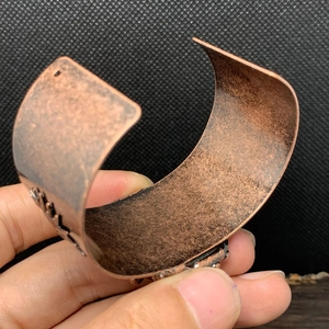 Detail eines Vintage-Kupferarmreifs mit ethnischen Gravuren und gewellten Kanten