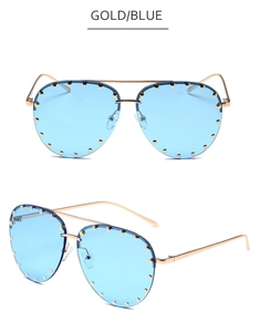 Detail view of gold aviator sunglasses with blue lenses and decorative metal rivets