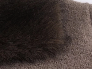 Gros plan détaillé du col en fausse fourrure marron foncé et du tissu en maille café