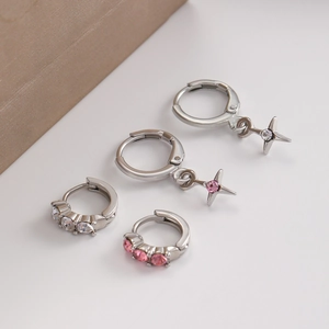 Detail of silver cross star earrings featuring sparkling white and pink zircon stones