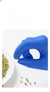 Detail of blue nitrile gloves with anti-slip textured fingertips for firm grip on small items