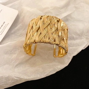 Minimalist woven wide cuff armlet in golden finish with textured metal wire design