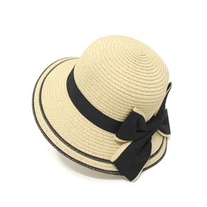 Detailed view of women's straw sun hat with woven texture and large black ribbon bow