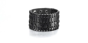 Macro shot of wide black braided leather bracelet with fine stitching and adjustable holes