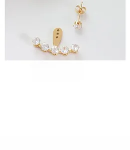 Detail of elegant gold-tone angel wing earring set with six clear cubic zirconia stones