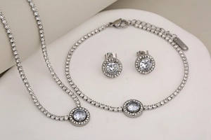 Detailed close-up of a silver stainless steel jewelry set with circular zircon pendants