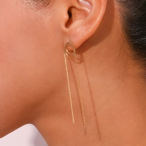 Close-up of golden stainless steel S-chain tassel earrings on model showing metal texture