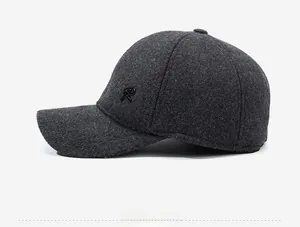 Side view of dark gray wool baseball cap with embroidered letter R and ear protection flaps