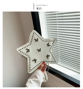 Detail of star-shaped crossbody bag with metal rivets and butterfly ornaments in beige