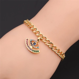 Detail showing a gold-plated evil eye bracelet with colorful zircons on a female wrist