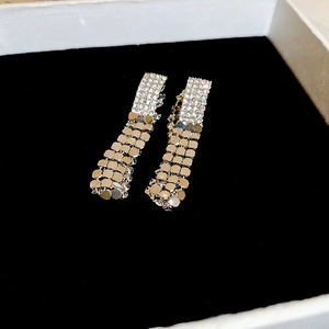 Macro view of long sequin tassel earrings with sparkling rhinestones in a gift box