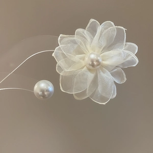 Close-up of organza flower earrings with pearl center and delicate asymmetric details