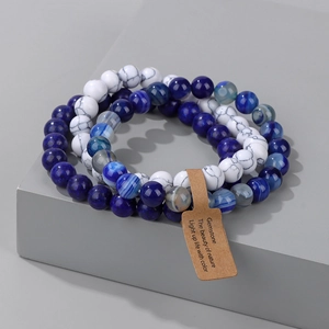 Detailed macro view of triple-layered gemstone beaded bracelets with marble and agate textures