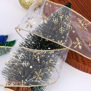 Sheer white Christmas organza ribbon with gold snowflake print wrapped on a festive tree