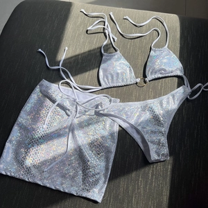 Detailed view of holographic snakeskin print bikini set with metal ring and skirt