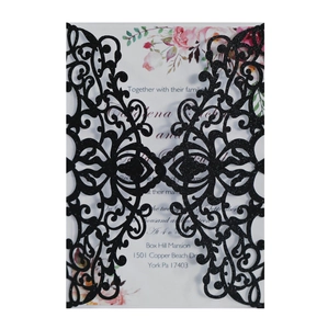 Macro detail of laser-cut black floral wedding invitation sleeve with white insert card