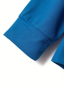 Dettaglio ravvicinato dei polsini in maglia a coste blu scuro di una tuta sportiva