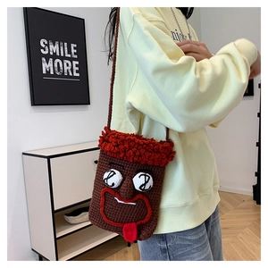 Braune Häkeltasche mit lustigem Gesicht Design getragen von Modell in einem gemütlichen Raum