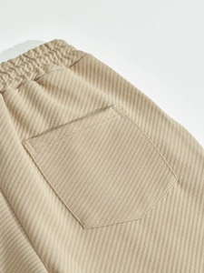 Dettaglio dell'elastico in vita e della tasca posteriore dei pantaloni beige