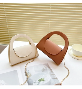 Detailed view of chic beige and brown leather handbags with elegant gold chain straps