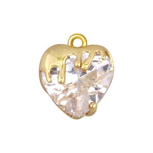Macro detail of a heart-shaped gold pendant with a clear faceted crystal and melting design