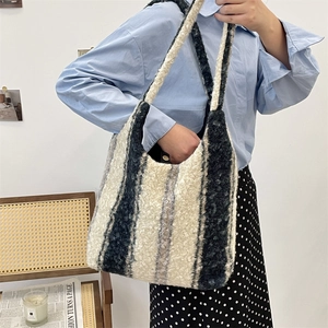Plush striped tote bag with black white and grey color blocks on a shoulder strap