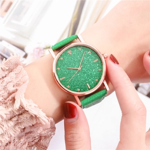 Primo piano dell'orologio verde cielo stellato con cassa in oro rosa sul polso donna