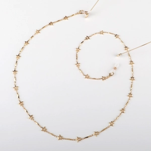 Detailed close-up of golden metal star-shaped link eyewear chain with adjustable silicone loops