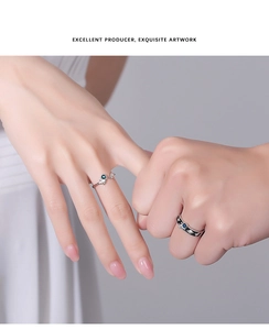 Detailed close-up of astronaut-themed couple rings with blue gemstones and star engraving