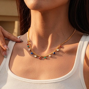 Detail of gold necklace with round multicolored crystal pendants on model
