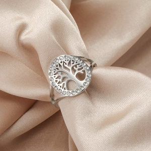 Detailed view of silver tree of life ring with sparkling crystals on silk background