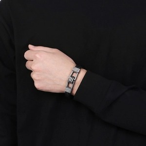 Detail of black braided leather bracelet featuring a vintage silver metal magnetic clasp