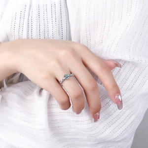 Fashionable open ring with round teal cubic zirconia and silver metal on a model's finger