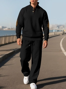 Detail of black ribbed knit track suit with brown elbow patches on the sleeves