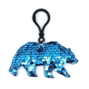 Detail shot of a sparkling blue sequin bear keychain with durable black clip hanger