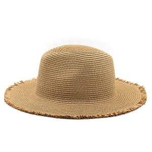 Detailed close-up of natural raffia straw weave with raw fringe edges on a summer fedora hat