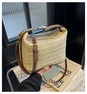 Dettaglio borsa in paglia beige con finiture in pelle marrone e fibbie dorate