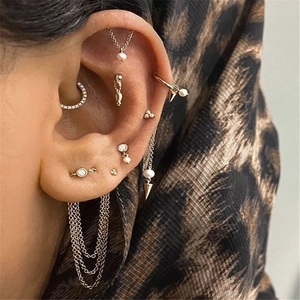 Detail of S925 silver gold tassel pearl earrings and zircon ear studs on a model