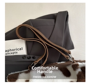 Detail of soft brown cow print faux fur texture with high-quality leather shoulder strap