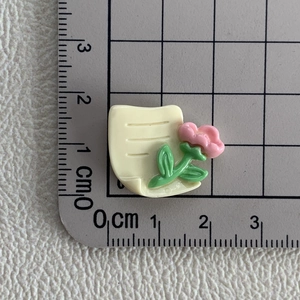 Vue détaillée d'accessoire fleur en résine sur règle graduée pour loisirs créatifs