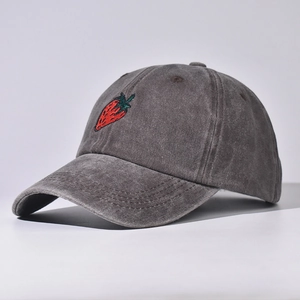 Dettaglio di un cappello da baseball grigio antracite lavato con ricamo a fragola.